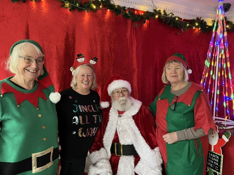 Santa with three others dressed as elves